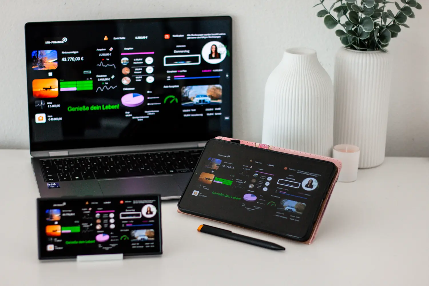Ein Setup mit drei elektronischen Geräten, die Teil eines persönlichen Finanz- oder Datenvisualisierungssystems zu sein scheinen, von MN Finance